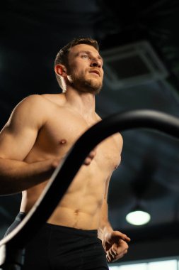 Erkek sporcu koşu bandında koşuyor.