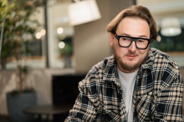 Genç çekici erkek tasarımcı kameraya gülümsüyor. Video konferansı, çağrı, profil fotoğrafı, yakışıklı iş adamı portresi, profesyonel meslek, insan konsepti