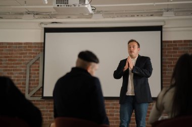 Şirketin genç iş adamı modern ofiste ofis personeli için finansal konferans sunuyor..