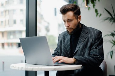 Kafede dizüstü bilgisayarla çalışan Kafkasyalı genç bir iş adamı. İşadamı, serbest çalışan.