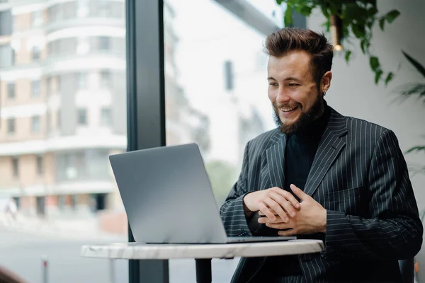 Young Caucasian business man zoom call on laptop in cafe. Businessman, freelance