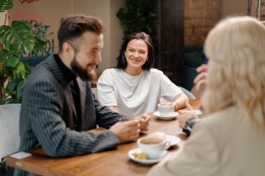 Adam hafta sonları iletişim kuran ve öğle yemeğini kafeteryada birlikte geçiren neşeli arkadaşlarıyla filtre kahve içiyor. Halka açık bir yerde buluşmak. Arkadaşlık..