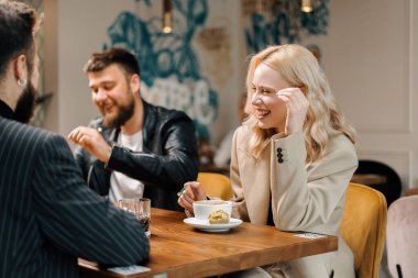 Keyifli arkadaşlar hafta sonları sosyalleşiyorlar. Birlikte vakit geçiriyorlar. Yemekhanede öğle yemeği yiyorlar. Halka açık bir yerde. Arkadaşlık..