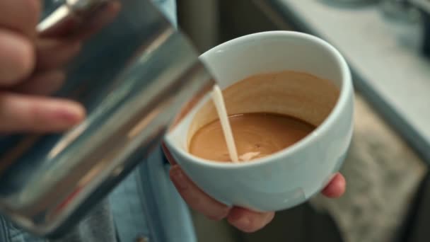 スペシャルティコーヒーショップでラテアートを作るバリスタ エスプレッソでミルクを注ぐプロの男 — ストック動画