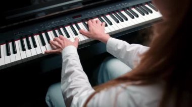 Close-up: a woman sensually plays the piano