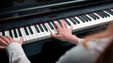 Close-up: a woman sensually plays the piano