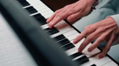 Close-up: a woman sensually plays the piano