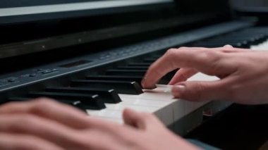 Close-up: a woman sensually plays the piano