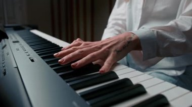Close-up: a woman sensually plays the piano