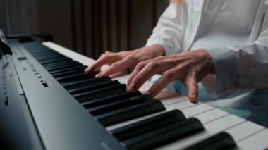 Close-up: a woman sensually plays the piano