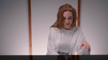 Woman sensually playing the piano view from the back