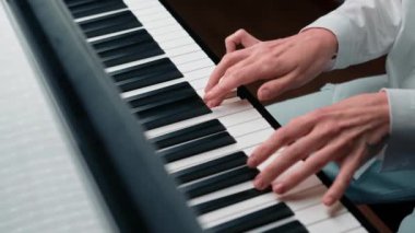 Piyano tuşuna seçici odaklanma ve piyano çalmak için parmaklar. Konser için müzik aleti ya da öğrenme müziği var. Sahnede piyano çalan çocuk müzisyenin eli kapalı..
