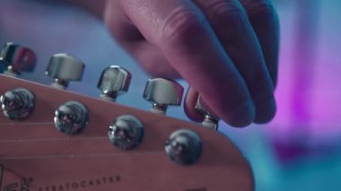 Close-up of a musician tuning a guitar