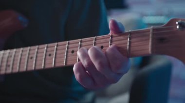 Man plays guitar in professional music studio. Man plays a musical instrument. Musician records his composition in a music Studio.