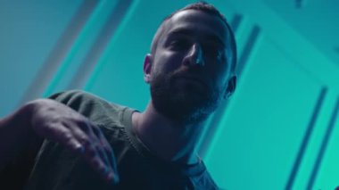 A music producer is dancing in a music studio. A man on drugs. Electonic music.