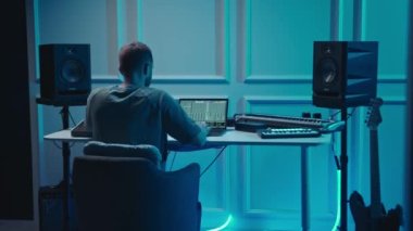 Music production studio. Producer. Man working in the recording studio with computer and mixer creating music in sound recording studio. Music production.