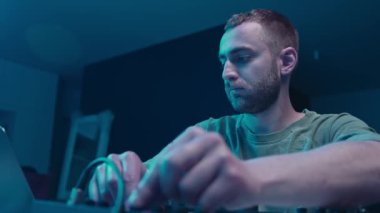 Music production studio. Producer. Man working in the recording studio with computer and mixer creating music in sound recording studio. Music production.