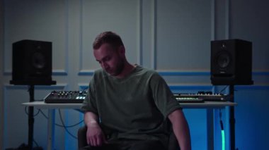 Music production studio. Producer. Man working in the recording studio with computer and mixer creating music in sound recording studio. Music production.