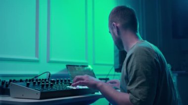 Music production studio. Producer. Man working in the recording studio with computer and mixer creating music in sound recording studio. Music production.