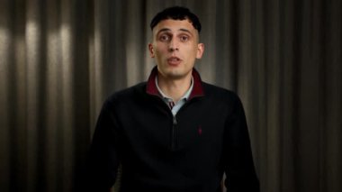 A male office worker communicates on zoom with colleagues at work (look at the camera), or conducts an interview