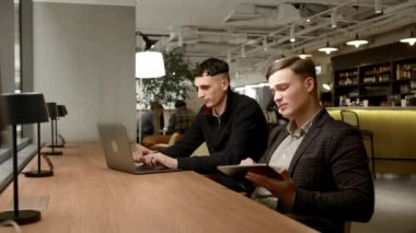 Male managers of the company work behind laptops