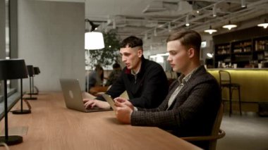 Male managers of the company work behind laptops