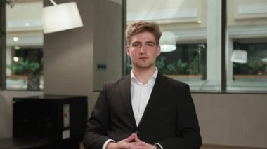 A male office worker communicates on zoom with colleagues at work (look at the camera), or conducts an interview