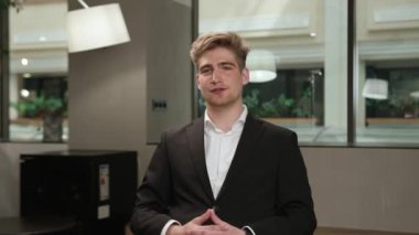 A male office worker communicates on zoom with colleagues at work (look at the camera), or conducts an interview