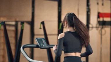 Woman athlete athlete is engaged in cardio training on the treadmill, thin sports girl