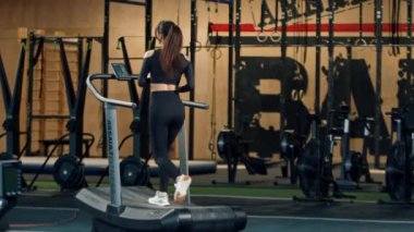 Woman athlete athlete is engaged in cardio training on the treadmill, thin sports girl