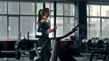 Woman athlete athlete is engaged in cardio training on the treadmill, thin sports girl