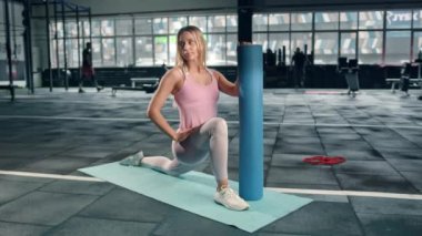 Flexible girl athlete does a stretch on a karemat