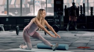 Flexible girl athlete does a stretch on a karemat