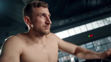 Young male athlete trains cardio on bike with fan, cardio training