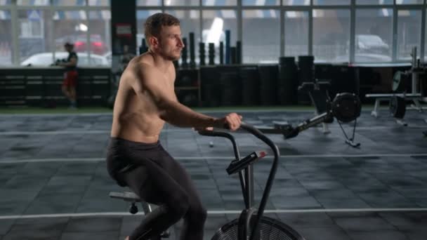 Young Male Athlete Trains Cardio Bike Fan Cardio Training — Wideo stockowe