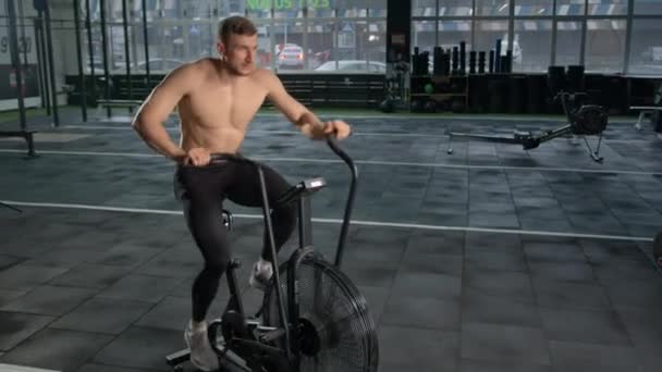 Young Male Athlete Trains Cardio Bike Fan Cardio Training — Video Stock