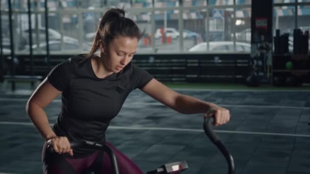 Young Female Athlete Trains Cardio Bicycle Fan Cardio Training — Vídeo de Stock