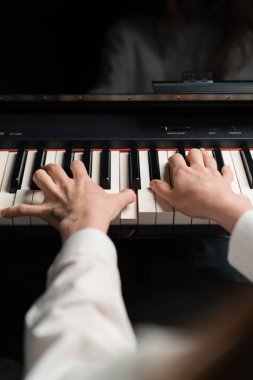 Rafine kadın piyanist ince parmaklarıyla piyano çalar, müzik aleti çalar.