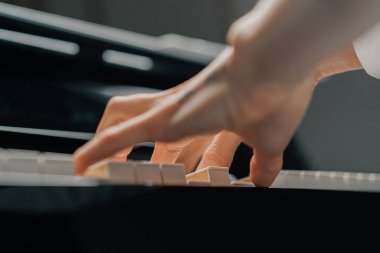 Rafine kadın piyanist ince parmaklarıyla piyano çalar, müzik aleti çalar.