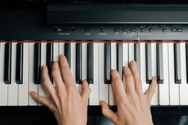 Üst görünüm: Rafine kadın piyanist ince parmaklarıyla piyano çalıyor, müzik aleti çalıyor