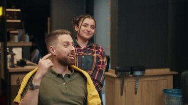 Barbershop: male client is very pleased with his haircut and praises barber