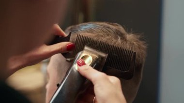 Barbershop: a woman barber cuts client's man's hair