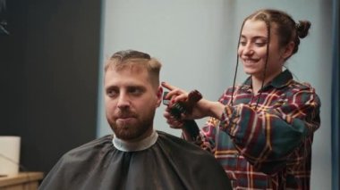 Barbershop: a woman barber cuts client's man's hair