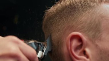 Barbershop: woman hairdresser cuts man's hair with razor