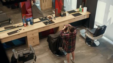 Barbershop: a woman barber cuts client's man's hair