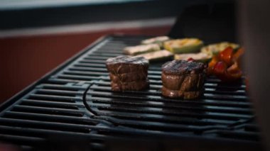 BBQ close-up: filet mignon steak and grilled vegetables cooking