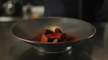 Chocolate brownie dessert is decorated with ice cream in professional restaurant kitchen