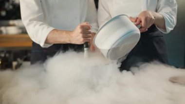 Close-up of a professional kitchen: liquid nitrogen is added during the preparation of molecular dish
