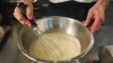 Milk is churned in a professional restaurant kitchen. Dessert cooking.