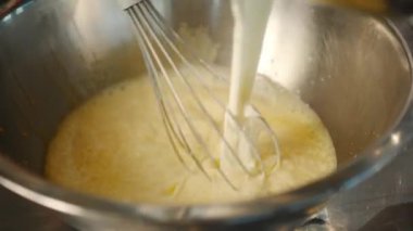 Milk is churned in a professional restaurant kitchen. Dessert cooking.